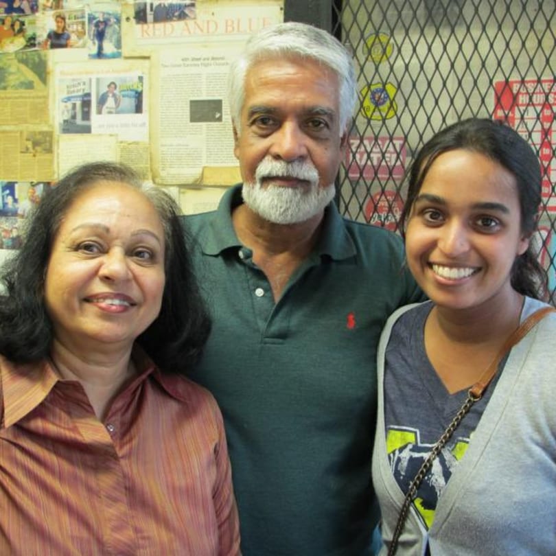 Three smiling people, two women and one man, stand together in Koch's Deli.